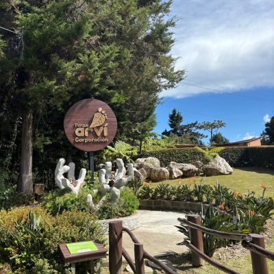 Entrance sign for Parque Arví near Medellín, Colombia, surrounded by landscaped gardens and native plants.