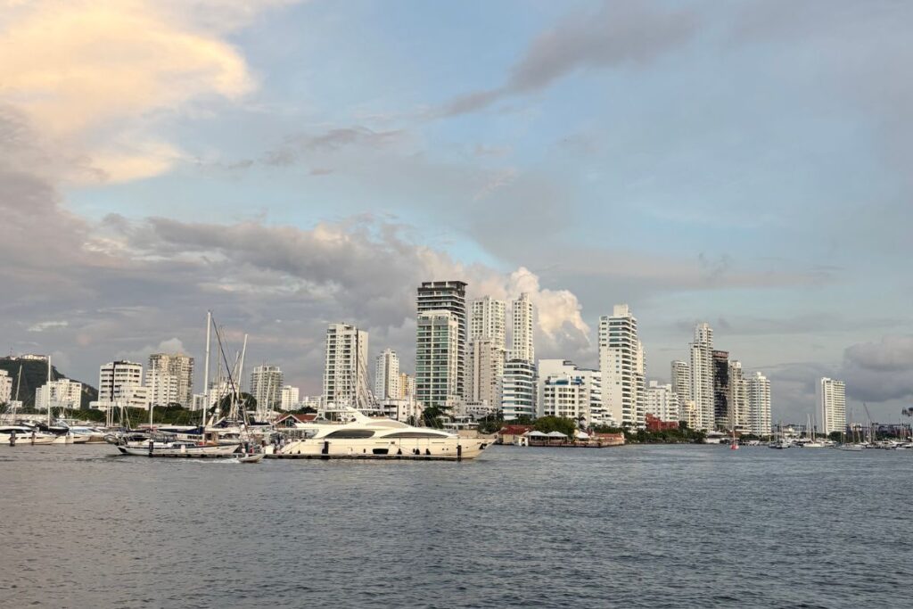 Luxury yachts docked along Cartagena’s marina with modern high-rise buildings in the background.