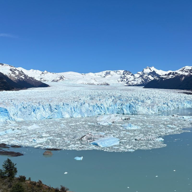 Glacier and mountain landscape in Patagonia, Argentina, with icebergs floating in turquoise water.
