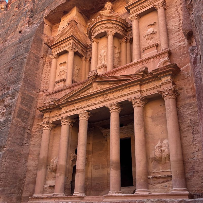 The Treasury at Petra, Jordan, carved into sandstone cliffs and viewed from the ancient archaeological site.