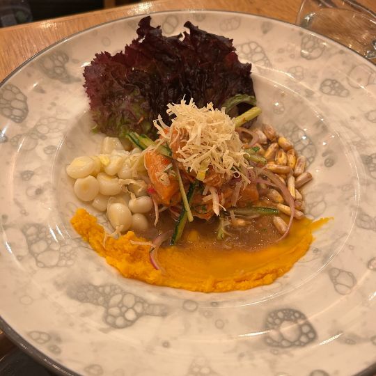 Traditional Peruvian ceviche plated with cancha corn, sweet potato purée, red onions, and lettuce at a restaurant in Peru.