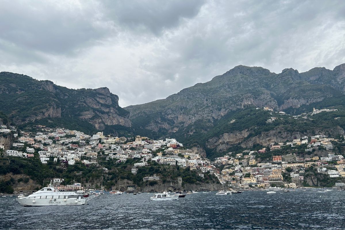 View of Positano and the Amalfi Coast from a ferry with mountains and cliffside buildings
