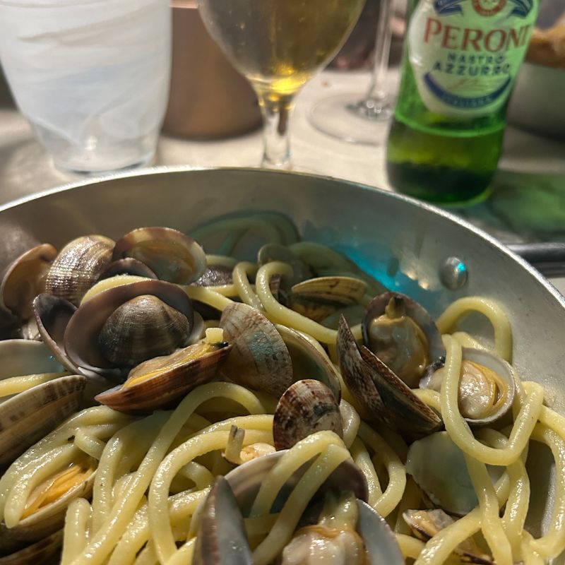 Bowl of spaghetti alle vongole with fresh clams served at an outdoor restaurant on Italy's Amalfi Coast.