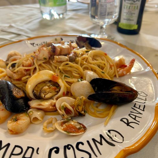 Plate of seafood pasta with shrimp, mussels, clams, and squid served at a restaurant on the Amalfi Coast.