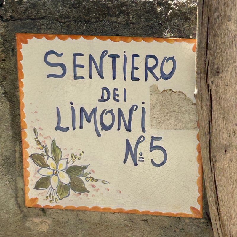 Ceramic sign marking the Path of the Lemons trail, a scenic walking route connecting towns along Italy's Amalfi Coast.
