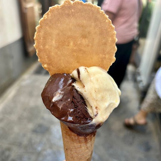 Chocolate and vanilla gelato served in a waffle cone while exploring a town on the Amalfi Coast.