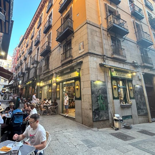 Outdoor churro cafés and restaurants along a pedestrian street in Madrid, Spain