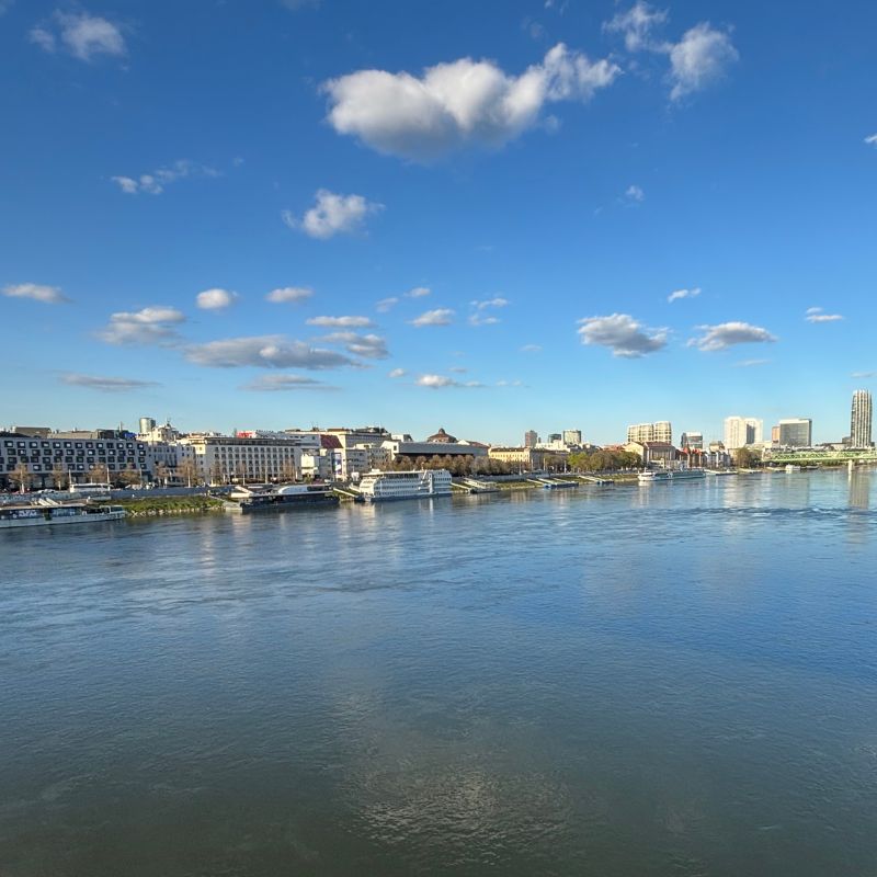 View across the Danube River toward Bratislava's waterfront and modern skyline on a sunny spring day