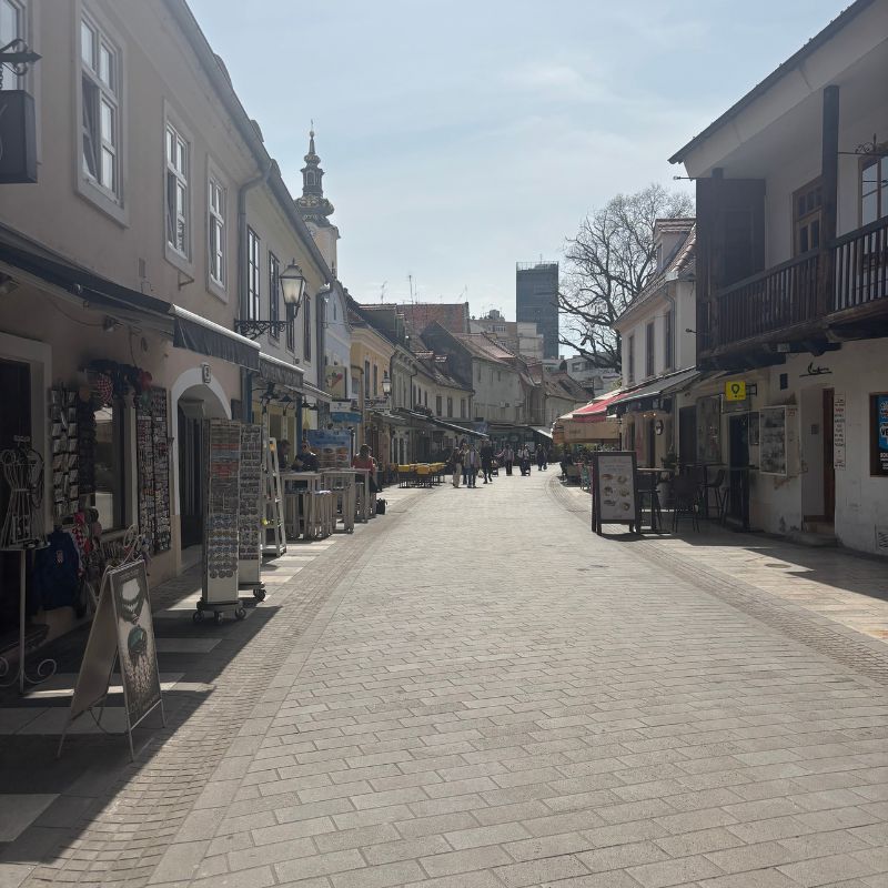 Pedestrian street lined with shops and cafés in Zagreb's historic center.