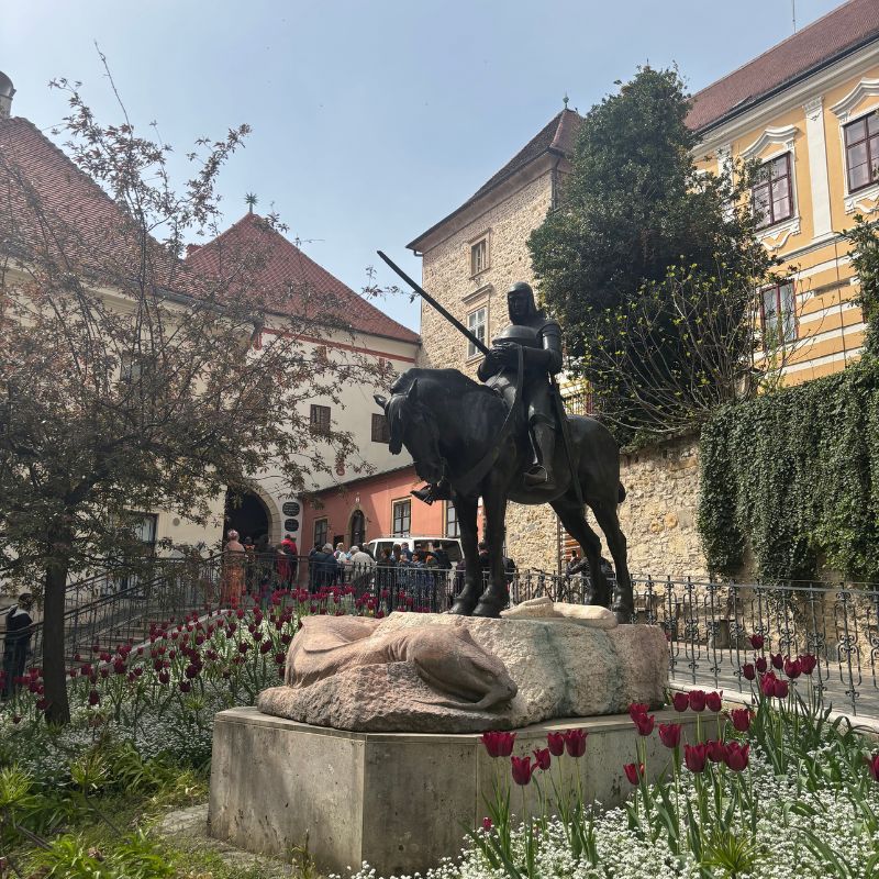 Equestrian statue surrounded by spring flowers in Zagreb's Upper Town, Croatia.