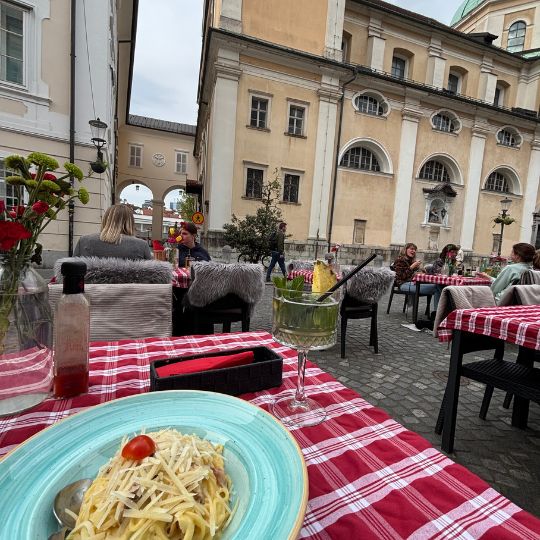 Outdoor dining in Ljubljana's Old Town with traditional Slovenian food and historic buildings.