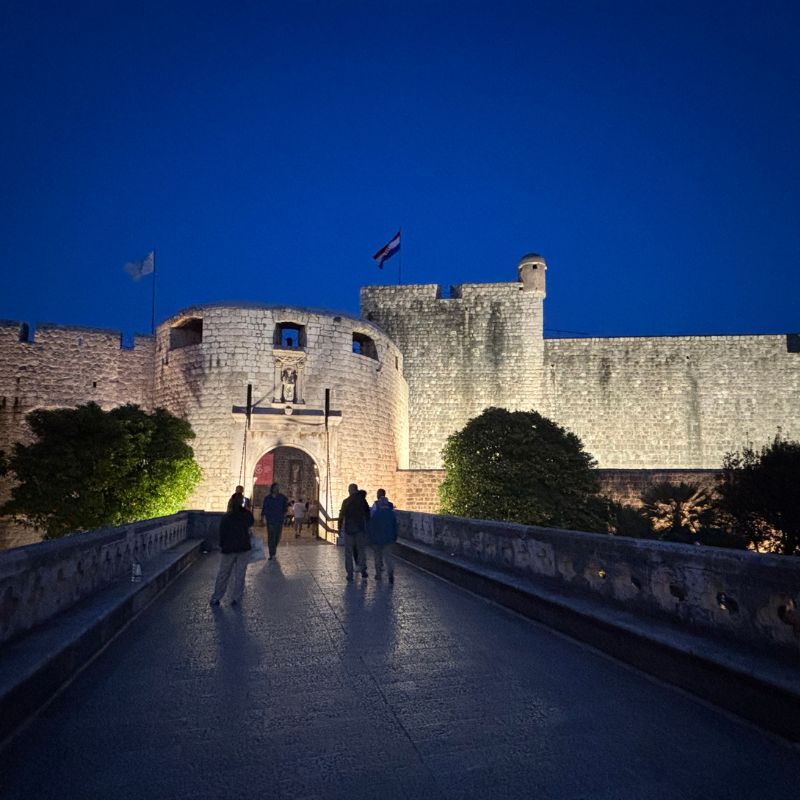 Pile Gate entrance to Dubrovnik Old Town illuminated at night.
