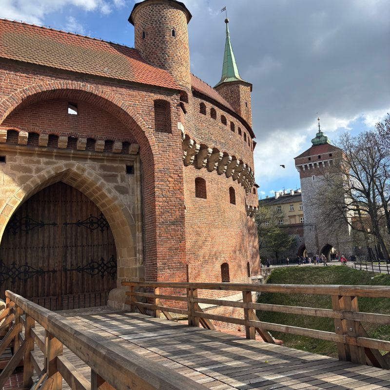 Historic brick walls and defensive towers of Kraków's medieval Barbican.