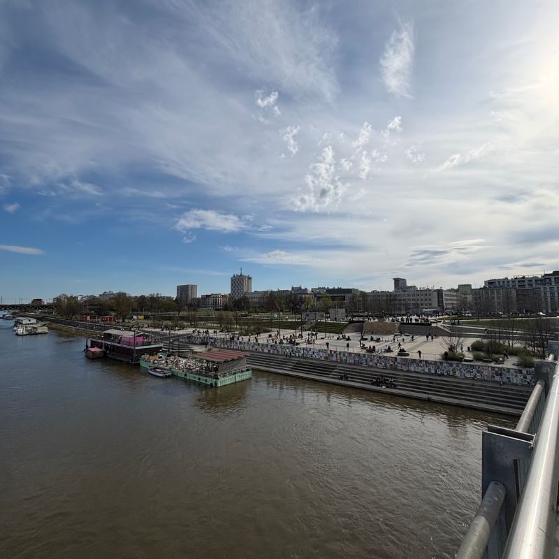 View across the Vistula River toward Warsaw's riverside promenades and public gathering spaces.