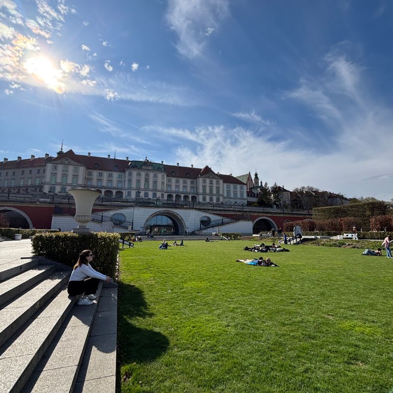 People relaxing on the lawns of Warsaw's Royal Castle Gardens overlooking the city.