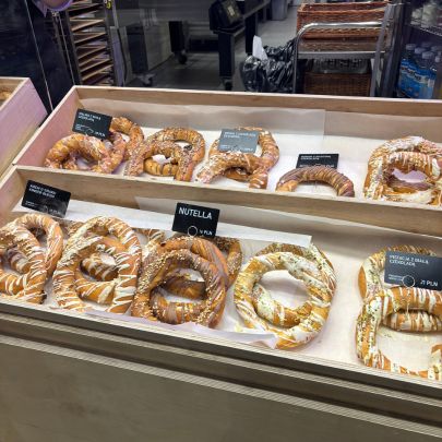 Bakery case filled with sweet and savory Polish pastries, including pretzels, cream-filled treats, and popular local snacks.