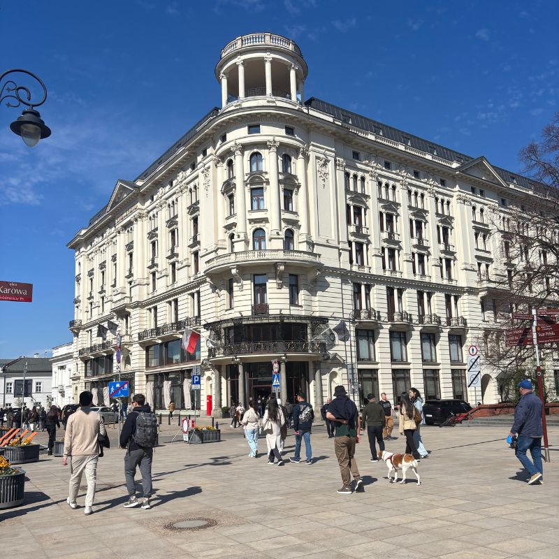 Elegant historic building near Kraków's Old Town, showcasing grand European architecture and lively pedestrian streets.