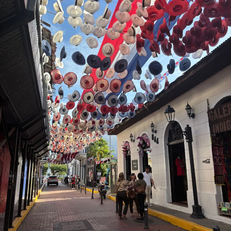 Colorful hats suspended above a narrow street in Casco Viejo, Panama City.