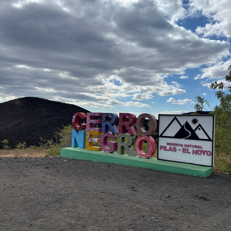 Colorful Cerro Negro sign marking the entrance to Reserva Natural Pilas–El Hoyo near León, Nicaragua.