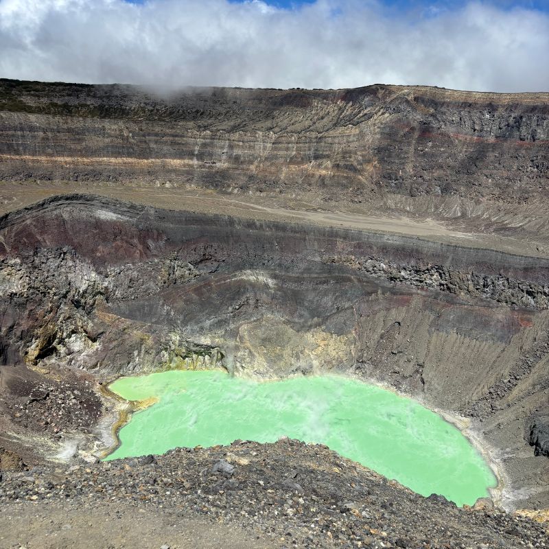 Turquoise crater lake inside Santa Ana Volcano (Ilamatepec), El Salvador, surrounded by steep volcanic walls and rocky terrain.
