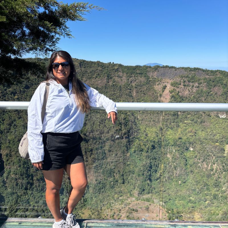 Traveler standing at a scenic overlook in El Boquerón National Park with lush volcanic landscapes stretching across El Salvador.