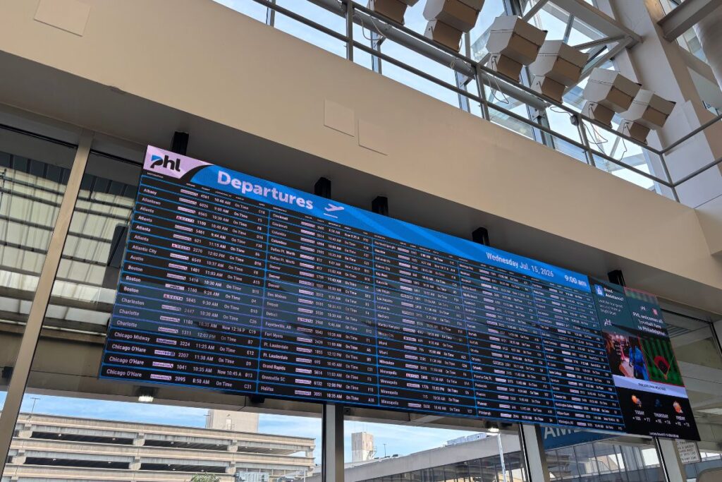 Departure board inside Philadelphia International Airport displaying flights from Terminal A, illustrating the starting point for building flexible one-way itineraries instead of traditional roundtrip bookings.