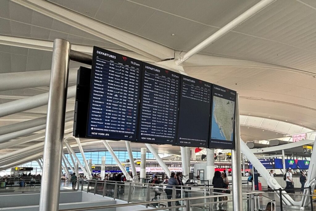 Electronic departures board at JFK Airport Terminal 4 displaying upcoming flights to destinations across the United States and beyond.