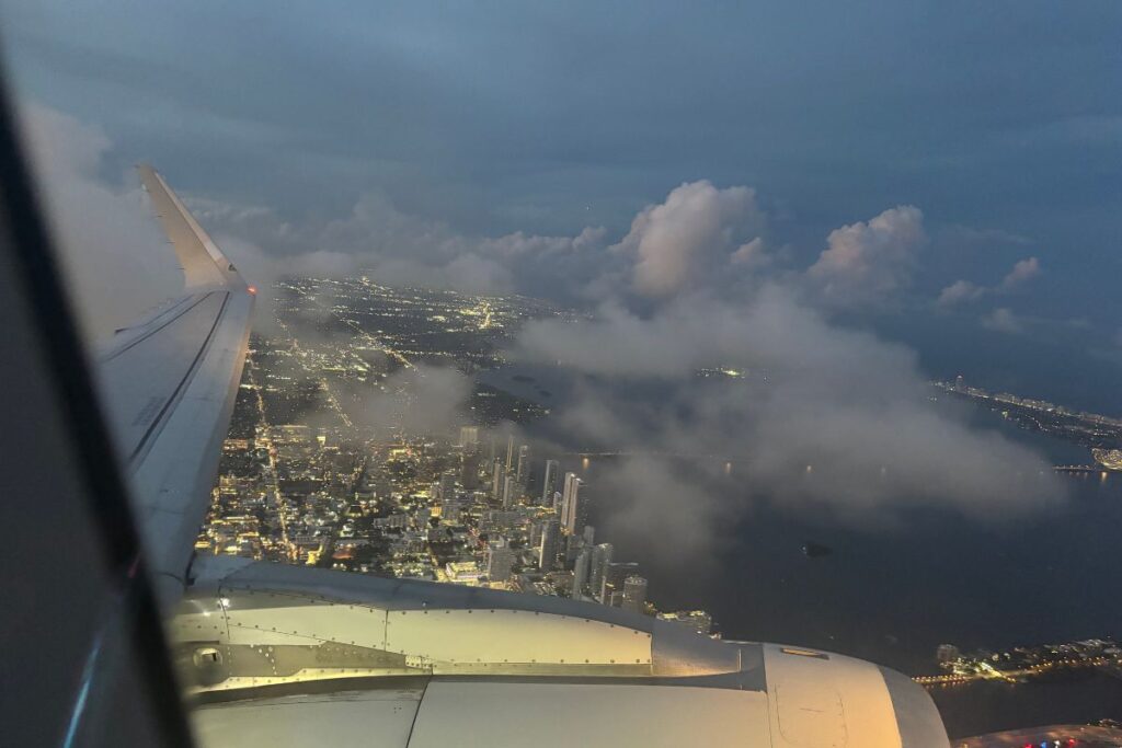 Airplane wing above city lights during an evening flight