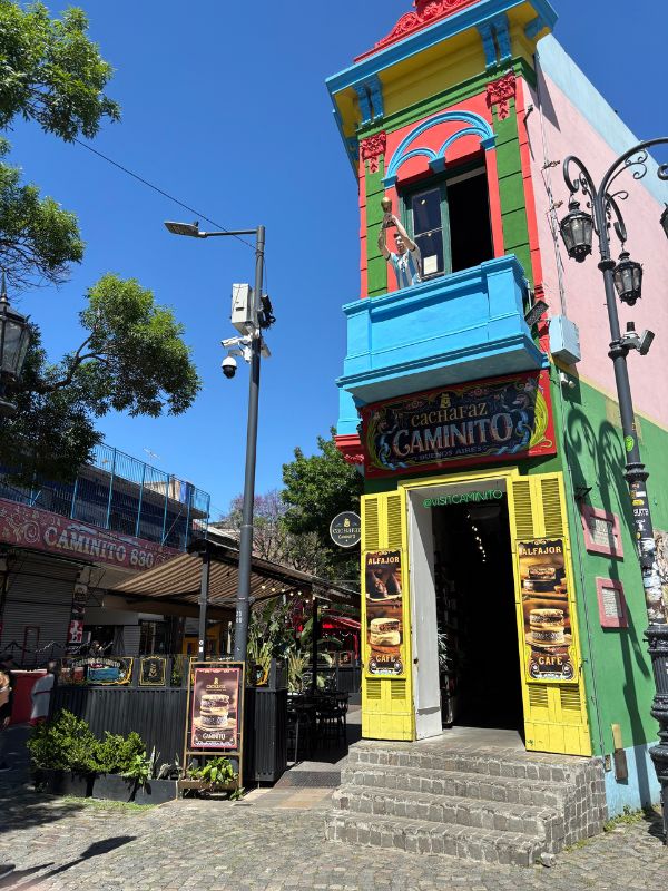 Colorful Caminito building with bright blue, pink, green, and yellow details in La Boca, Buenos Aires.