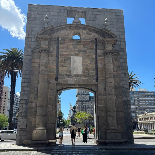 Historic Puerta de la Ciudadela gateway framing Plaza Independencia and Palacio Salvo in Montevideo.