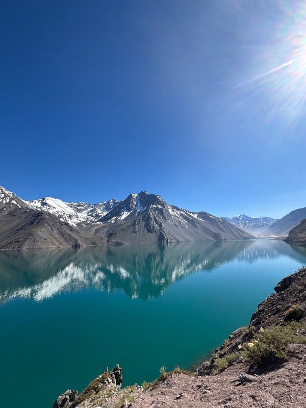 Turquoise waters of Embalse El Yeso surrounded by snow-capped Andes Mountains near Santiago, Chile.