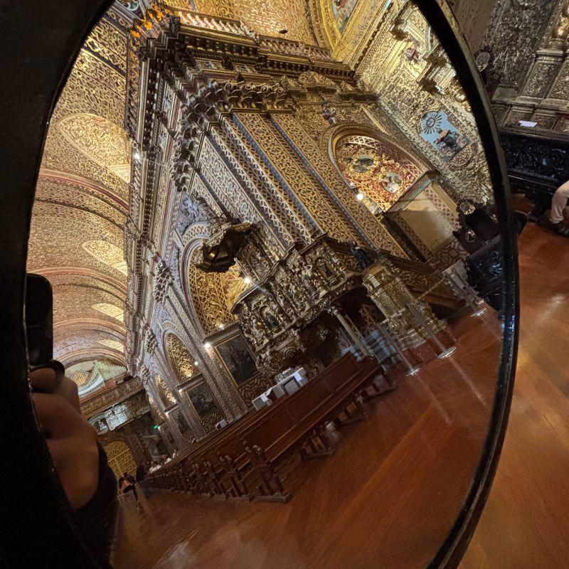 Ornate gold-covered interior of La Compañía de Jesús church in Quito, Ecuador, featuring richly decorated ceilings, arches, and altar.