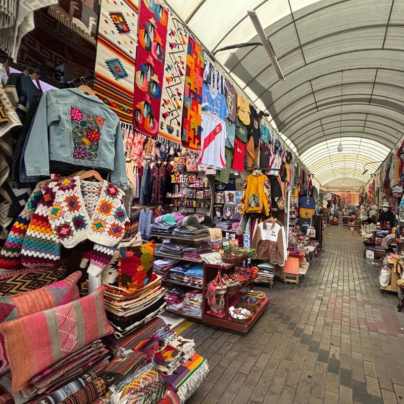 Colorful textiles, clothing, and souvenirs inside an artisan market in Miraflores
